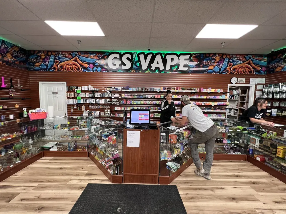 GS Vape sign with colorful graffiti mural backdrop above the sales counter in Barberton, Ohio store