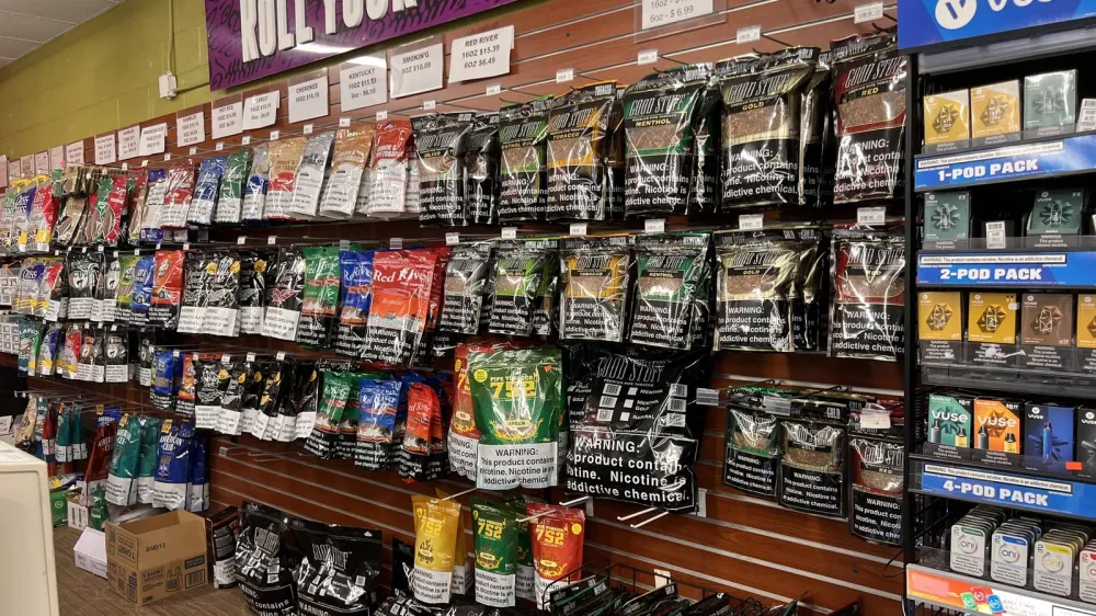 Wall of loose pipe tobacco brands with price signs under a Roll Your Own banner at GS Vape in Barberton, Ohio