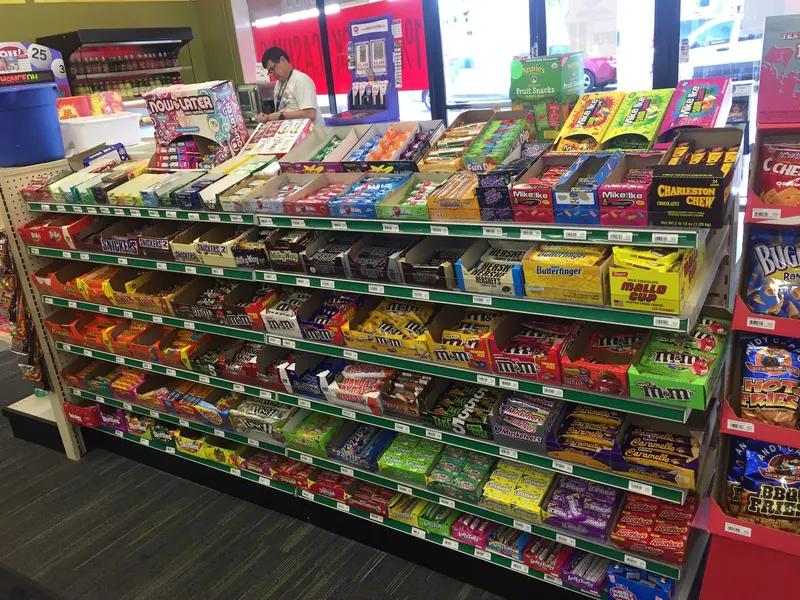 Our candy aisle stretches wall to wall with everything from Hershey's and M&M's to Mike and Ike and sour Skittles. It's the perfect stop to grab a sweet treat alongside your vape, tobacco, or lottery pickup. Candy and chocolate bar aisle with Snickers, M&M's, and Mike and Ike at GS Vape in Barberton, Ohio.
