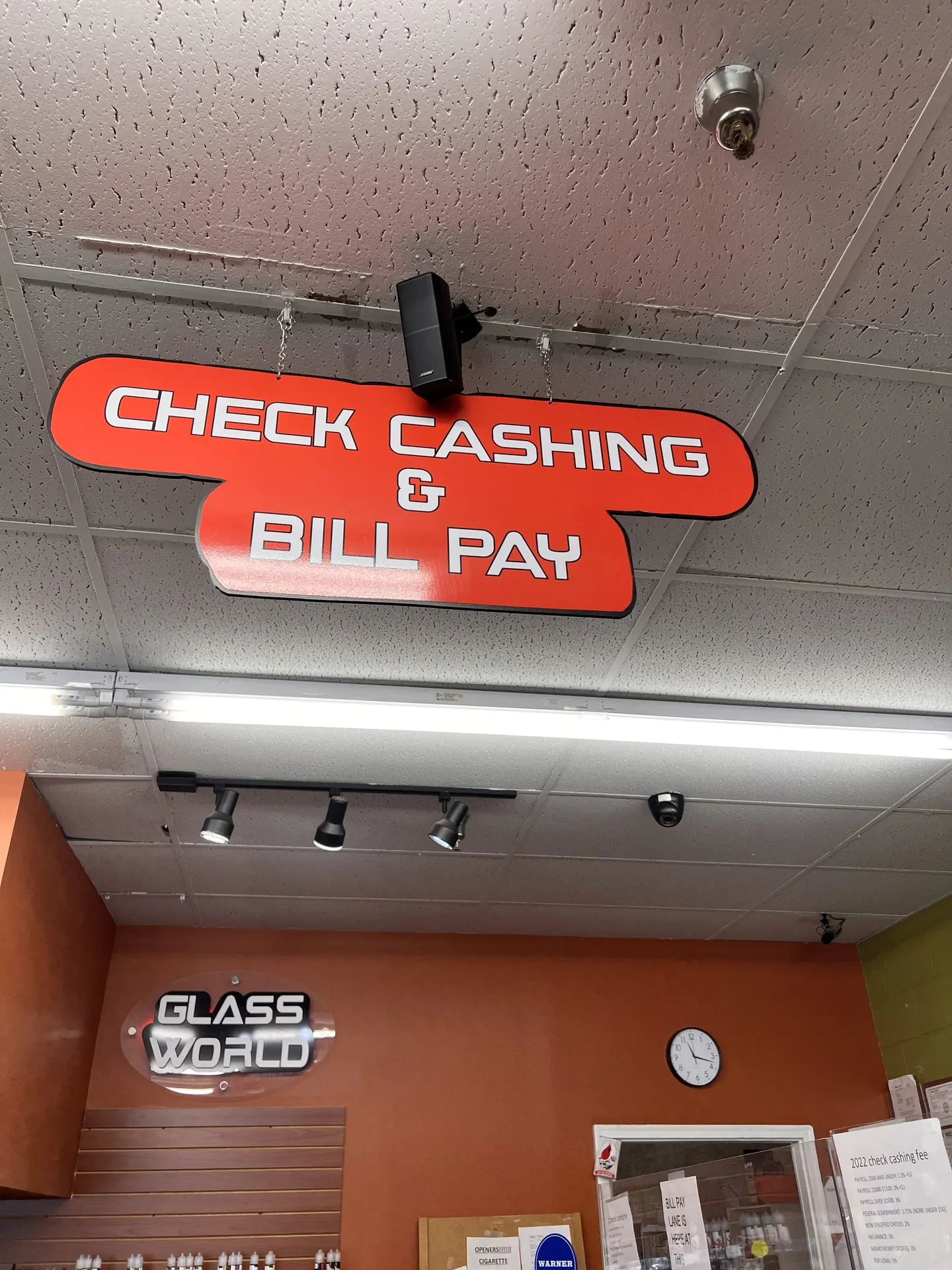 Check Cashing and Bill Pay hanging ceiling sign above the service counter at GS Vape Beer & Tobacco in Barberton, Ohio.