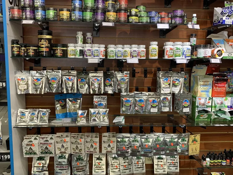 Wall of kratom capsules, powders, and OPMS brand pouches at GS Vape Beer & Tobacco in Barberton, Ohio.