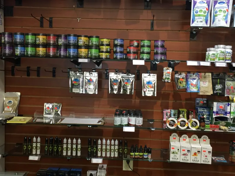 Colorful kratom powder tins including Maeng Da and Indo Bali lined up on a wall display at GS Vape Beer & Tobacco in Barberton, Ohio.