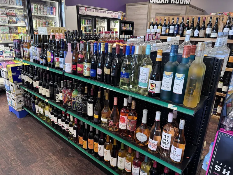 GS Vape Madison's wine shelves are stocked with a rotating selection of rose and white wines for every taste and occasion. The cigar room signage overhead marks the path to the store's walk-in humidor. Rose and white wine shelf display at GS Vape wine shop in Madison, Ohio