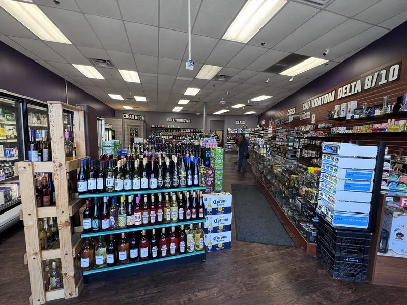 Inside GS Vape Madison, shoppers find a spacious layout combining wine and liquor shelves with a dedicated cigar room and CBD, kratom, and Delta 8 section. The store's wide aisles make it easy to browse every category in one visit. Interior overview of GS Vape store in Madison, Ohio showing wine aisle, cigar room, and CBD wall